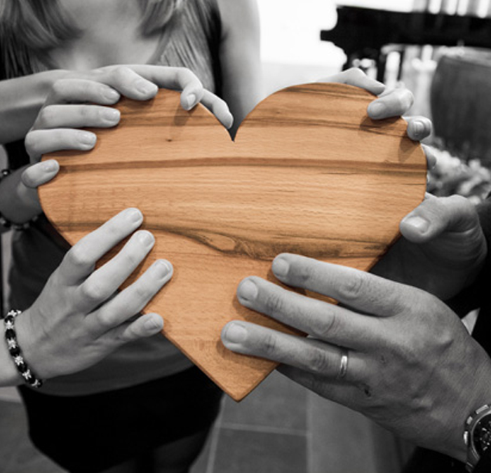 people holding a wooden heart
